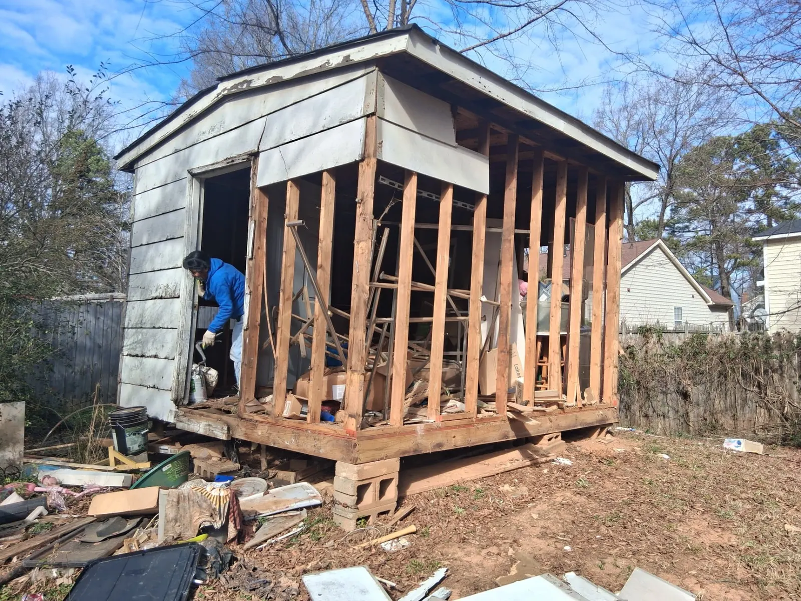 Budget Junk & Demo crew member demolishing a backyard storage shed in Charlotte, NC
