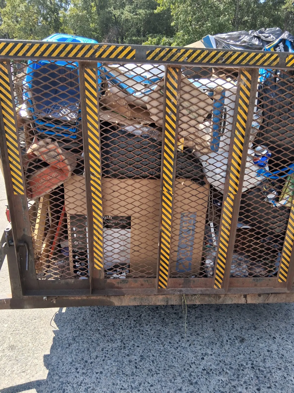 Dump trailer loaded with household junk, boxes and mattresses after a Charlotte, NC junk removal job